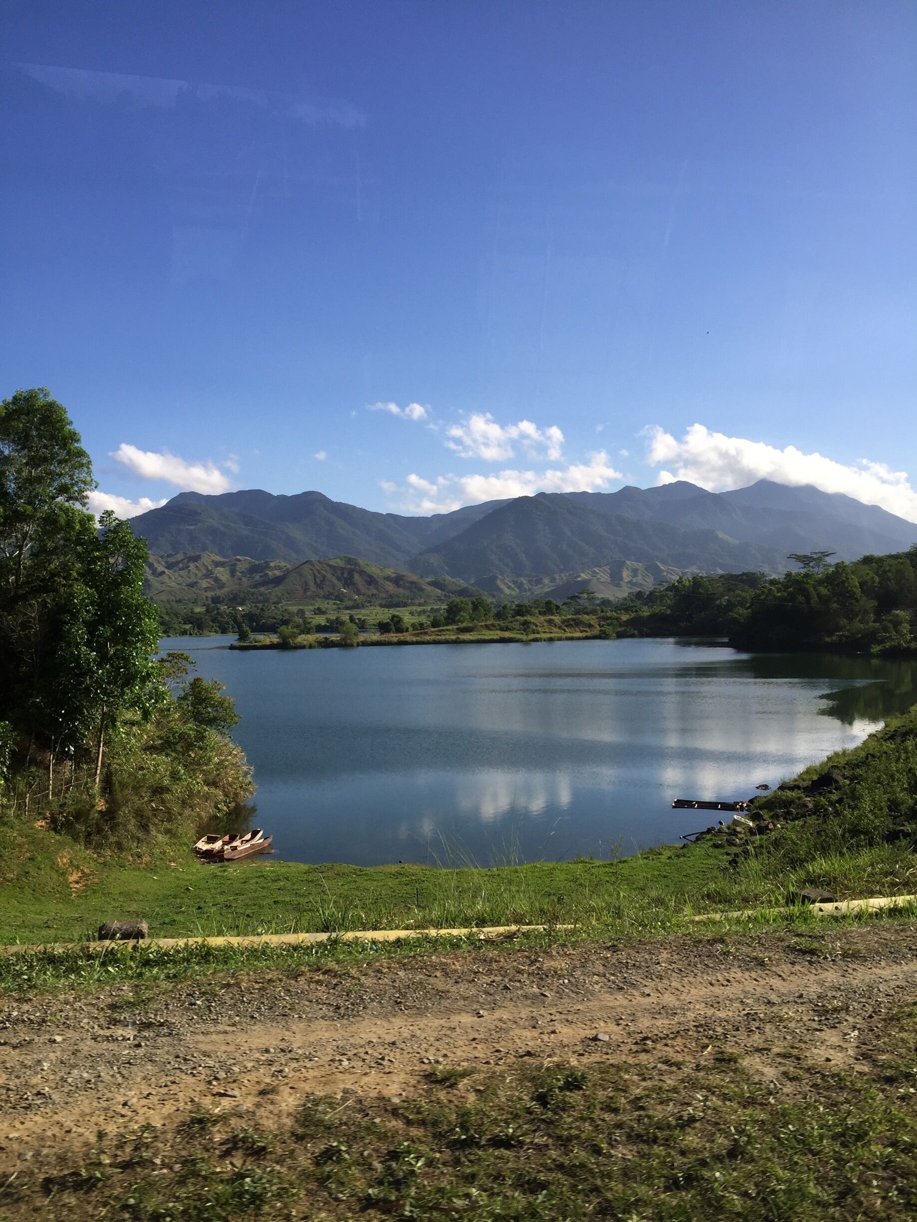 A lake surrounded by mountains and greenery.