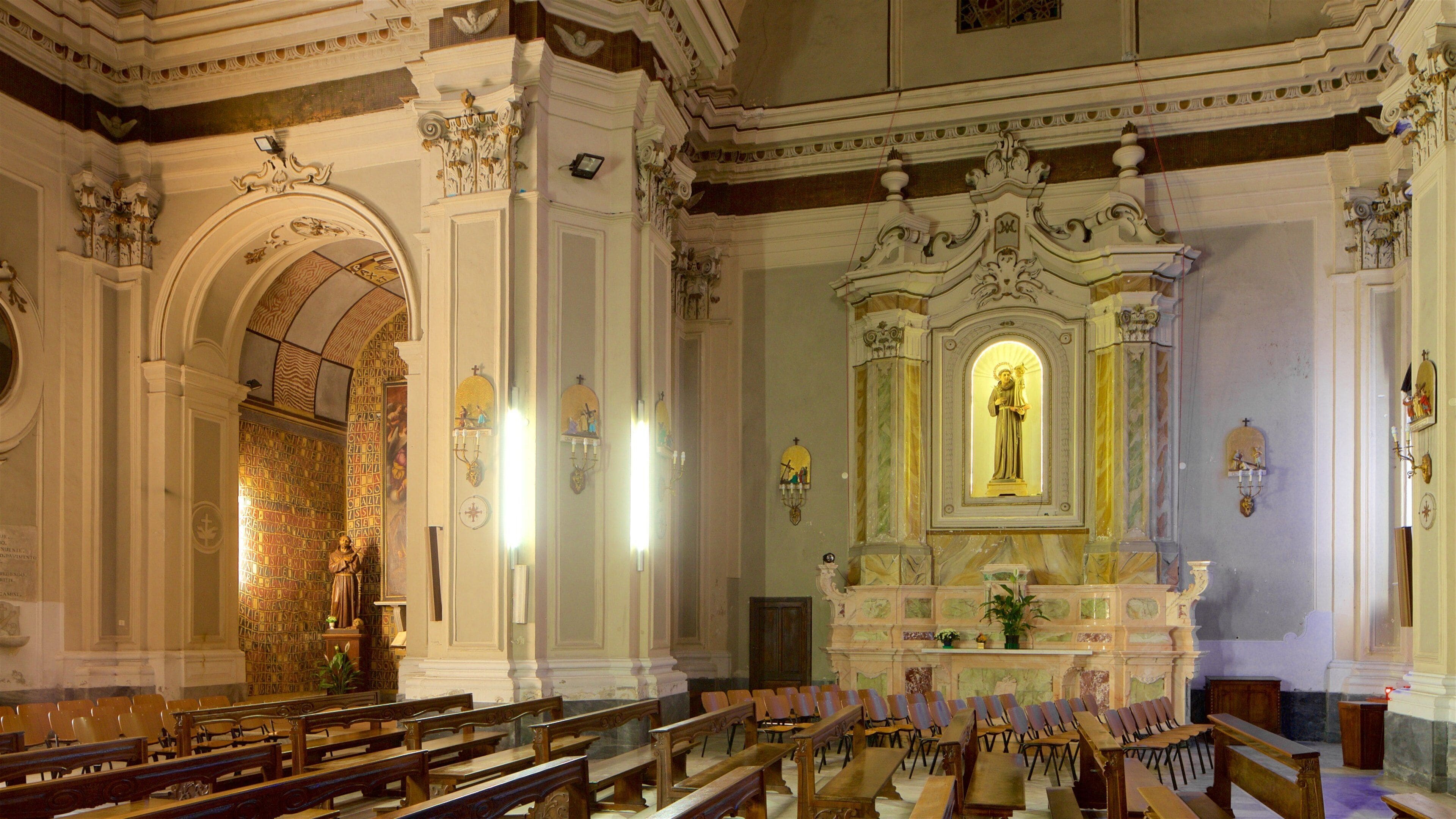 Interior d'una església amb elements decoratius, pews de fusta, un altar central i detalls a les parets.