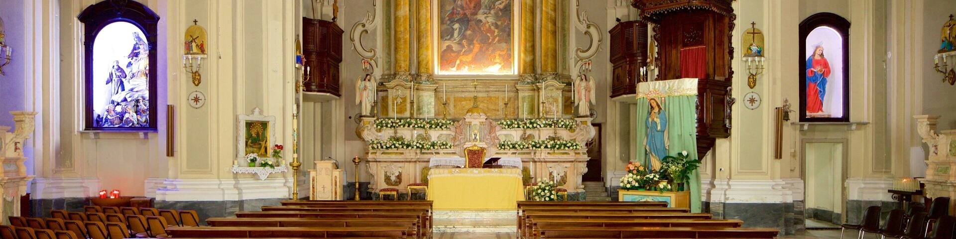 Interior de una iglesia ricamente decorada, con un altar central, vidrieras y ornamentación elaborada en el techo.