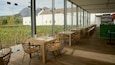 A restaurant with outdoor seating overlooking a vineyard and a mountain.