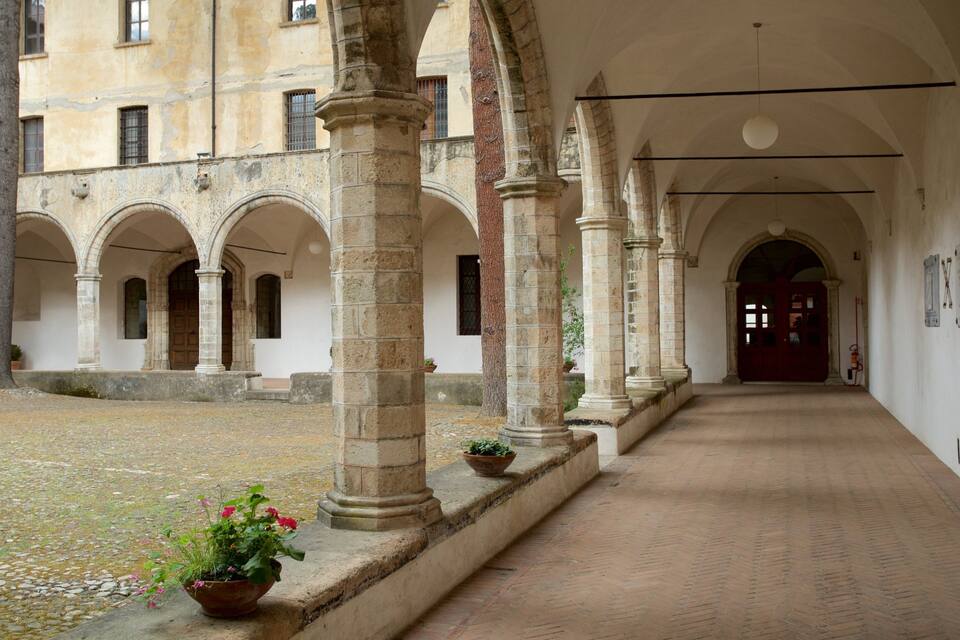 Ein Innenhof mit Steinsäulen, Bögen und einem Ziegelweg.