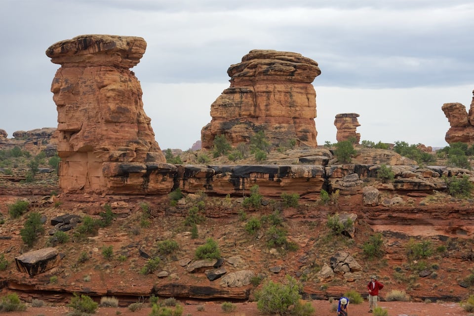 Rock formations with a person and another person in the foreground.