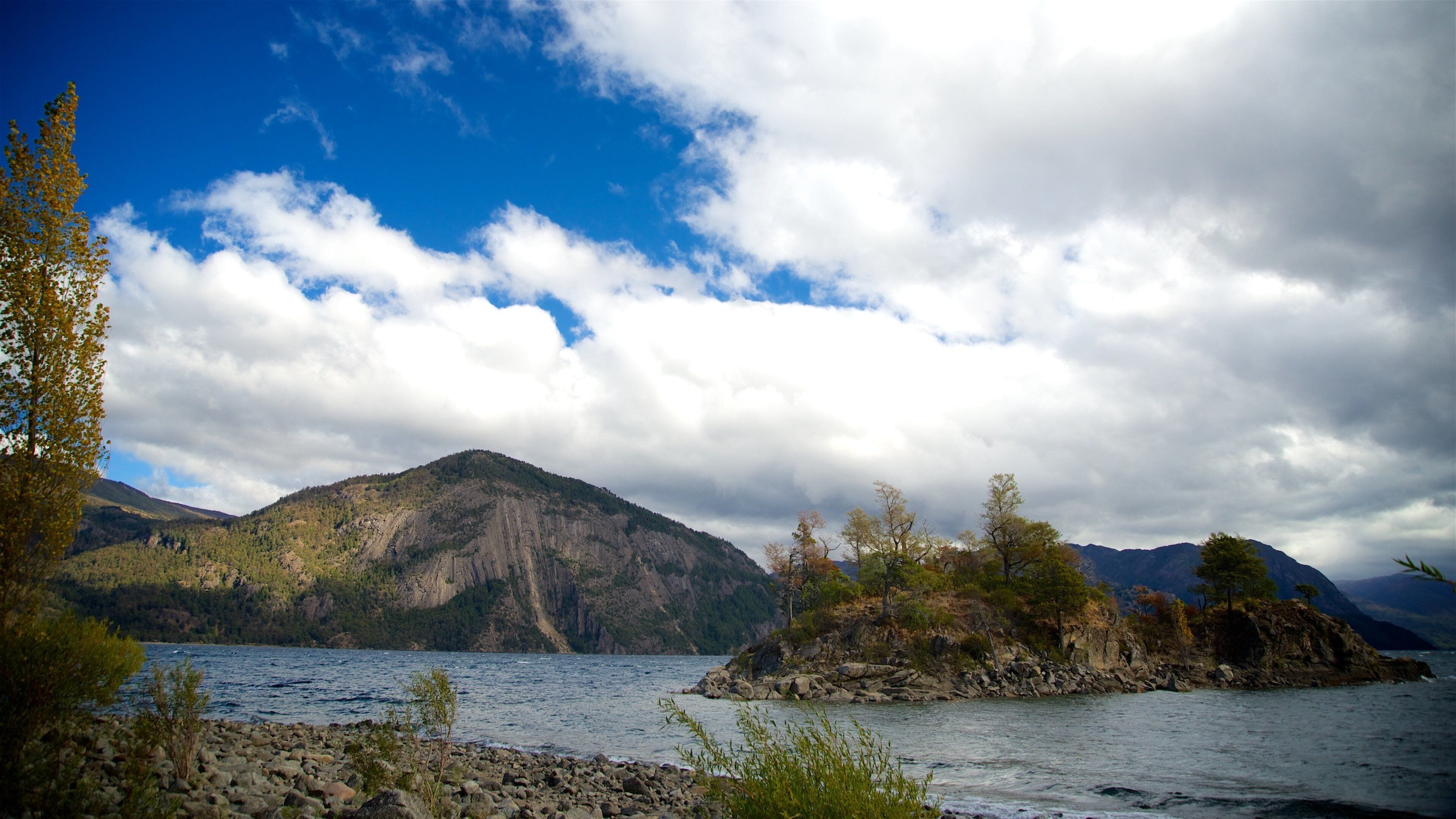 San Martín de los Andes som viser en sø eller et vandhul, en stenstrand og bjerge