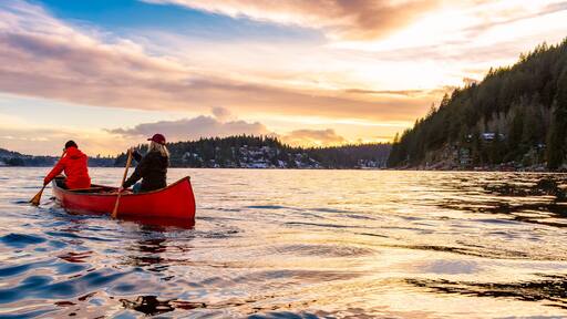 People on Wooden canoe paddling in water. Indian Arm, Deep Cove, North Vancouver