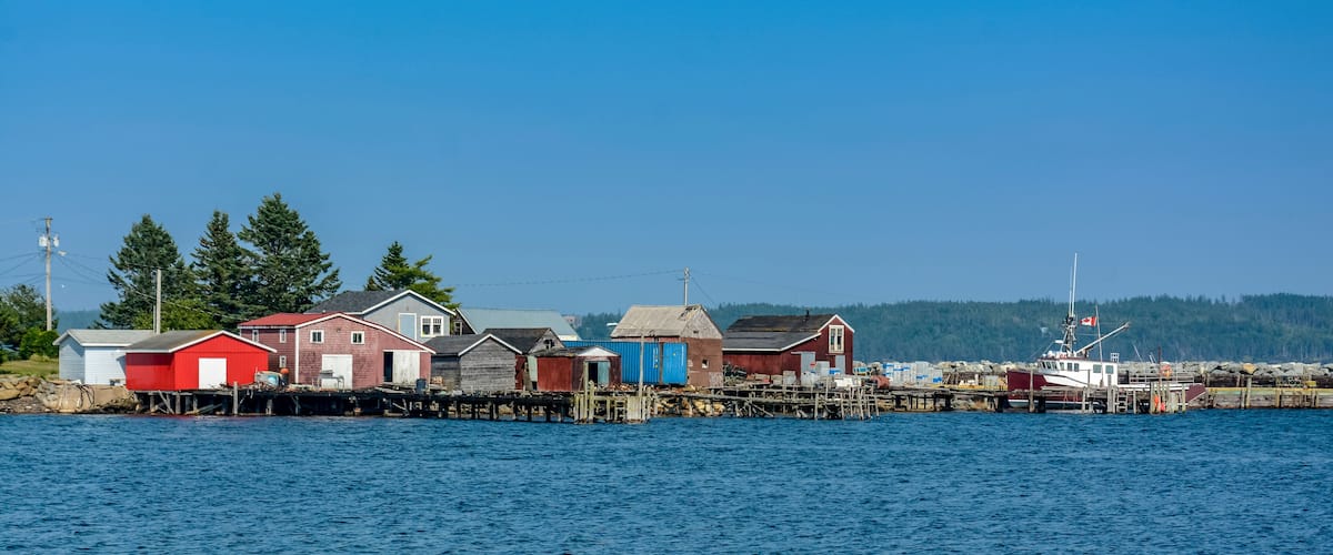 A coastal village with wooden houses and a dock.