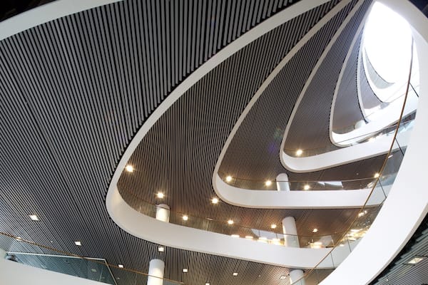 Une structure architecturale moderne dotée d’un plafond incurvé et de plusieurs niveaux.