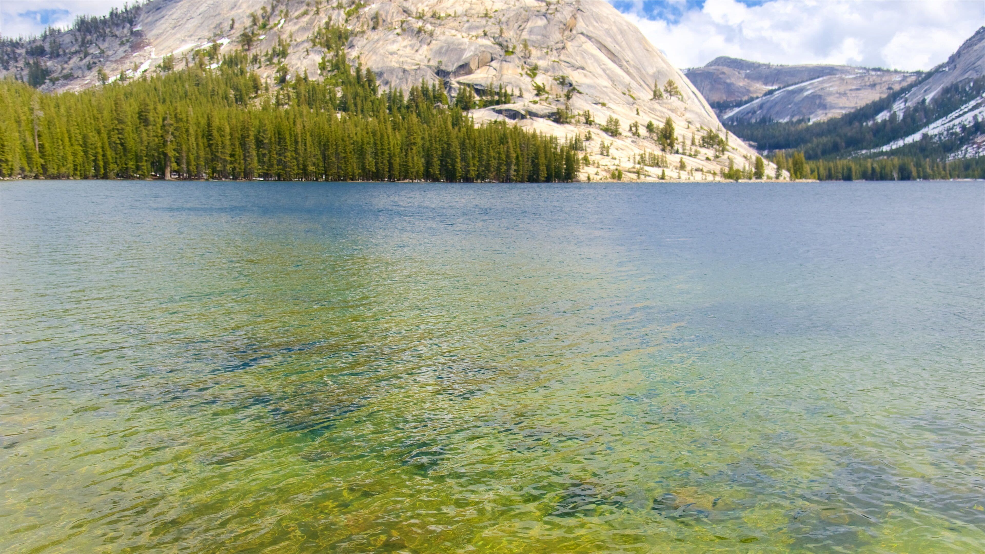 A clear lake with a mountain in the background.
