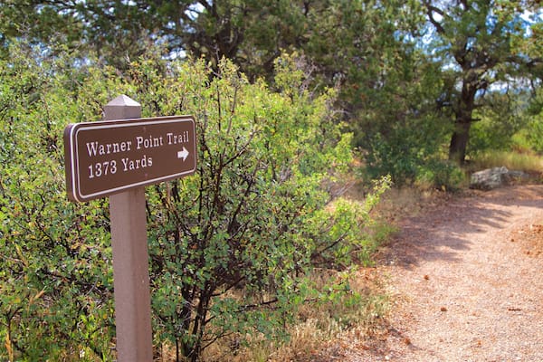 Placa de trilha indicando a Trilha Warner Point a 1373 Yards.