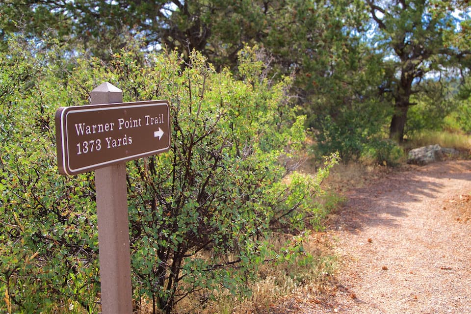 A trail sign for Warner Point Trail at 1373 Yards.