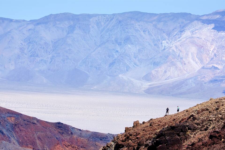 A vast salt flat with rugged mountains in the background.