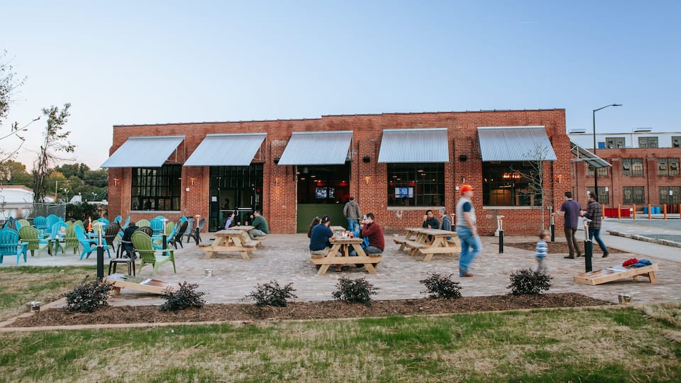 NoDa Brewing Company showing outdoor eating as well as a small group of people