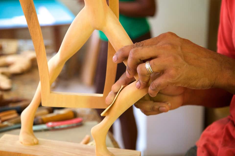 A person assembling a wooden sculpture.