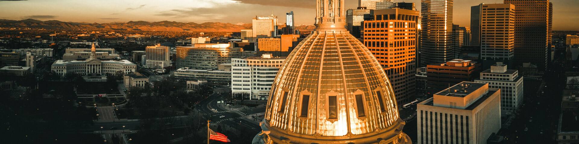 A cityscape with a prominent dome structure, a tall tower, and modern skyscrapers.