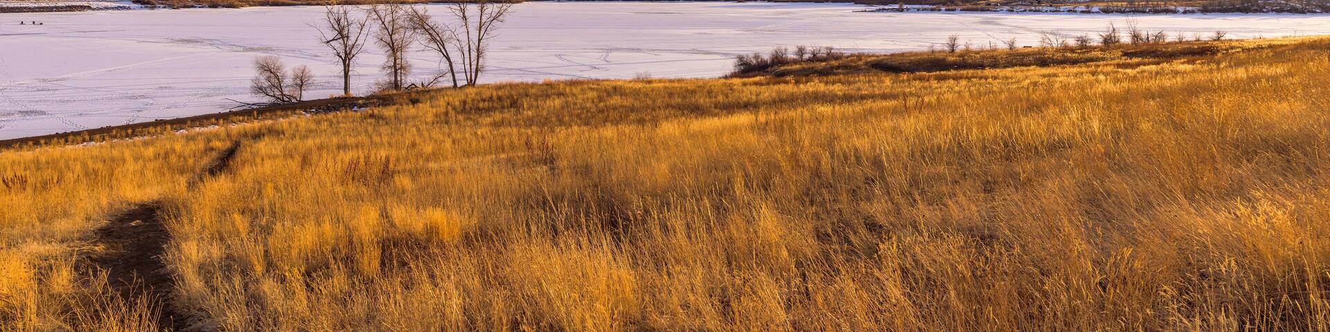 Sunset Winter Mountain Lake - A bright golden sunset at a frozen mountain lake. Bear Creek Lake Park, Denver-Lakewood-Morrison, Colorado, USA.