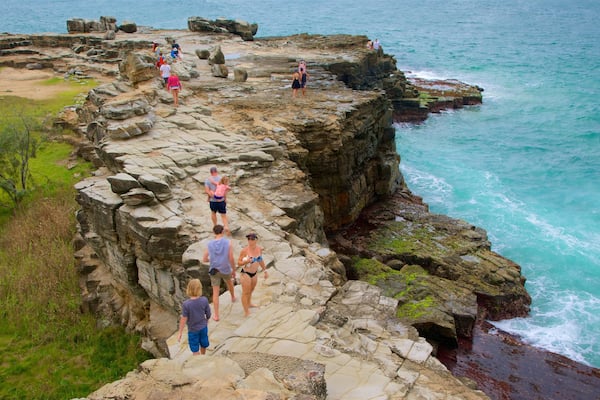 Yamba welches beinhaltet schroffe Küste sowie große Menschengruppe