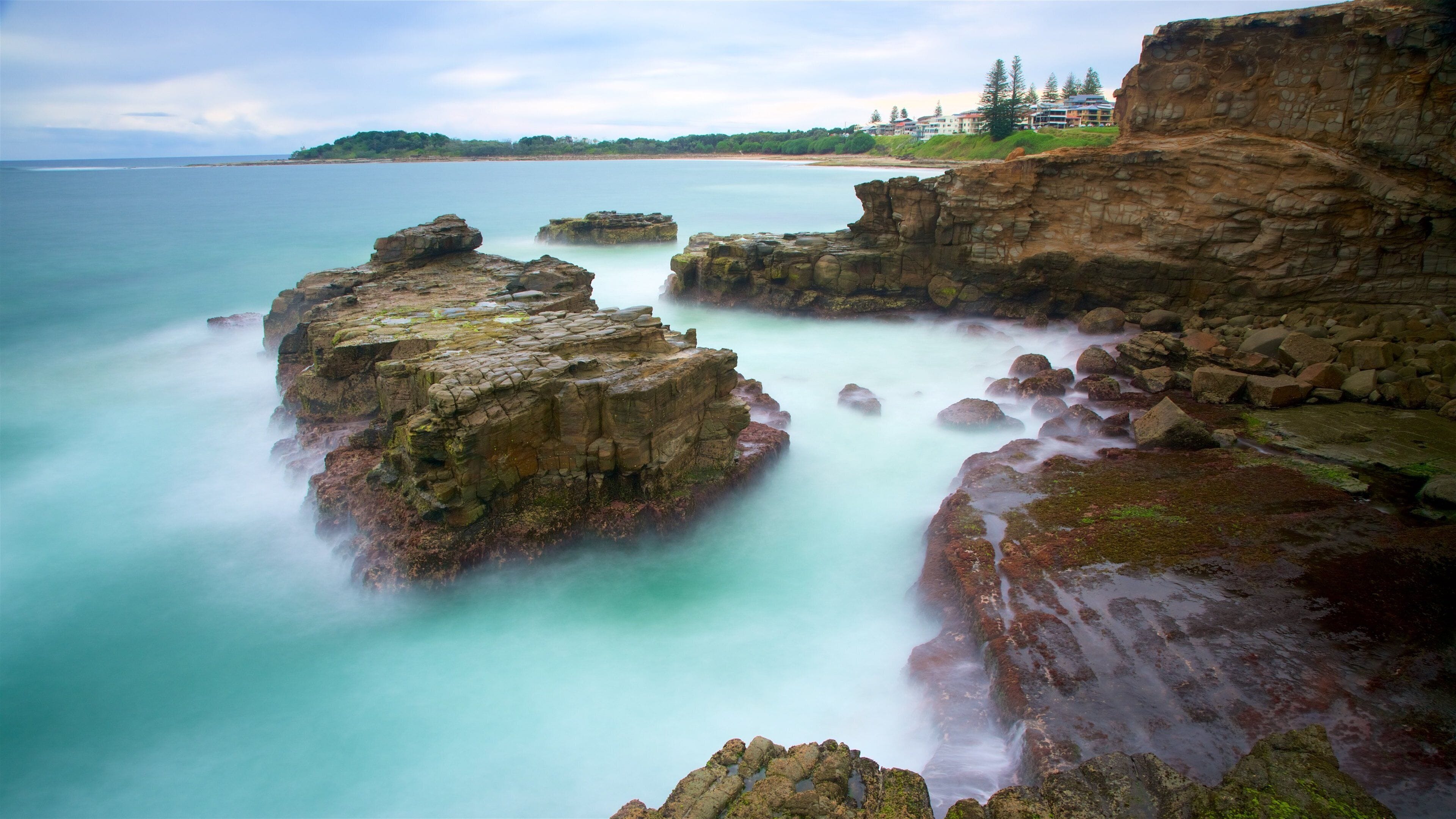 Un paisaje costero con formaciones rocosas y aguas turquesas tranquilas.