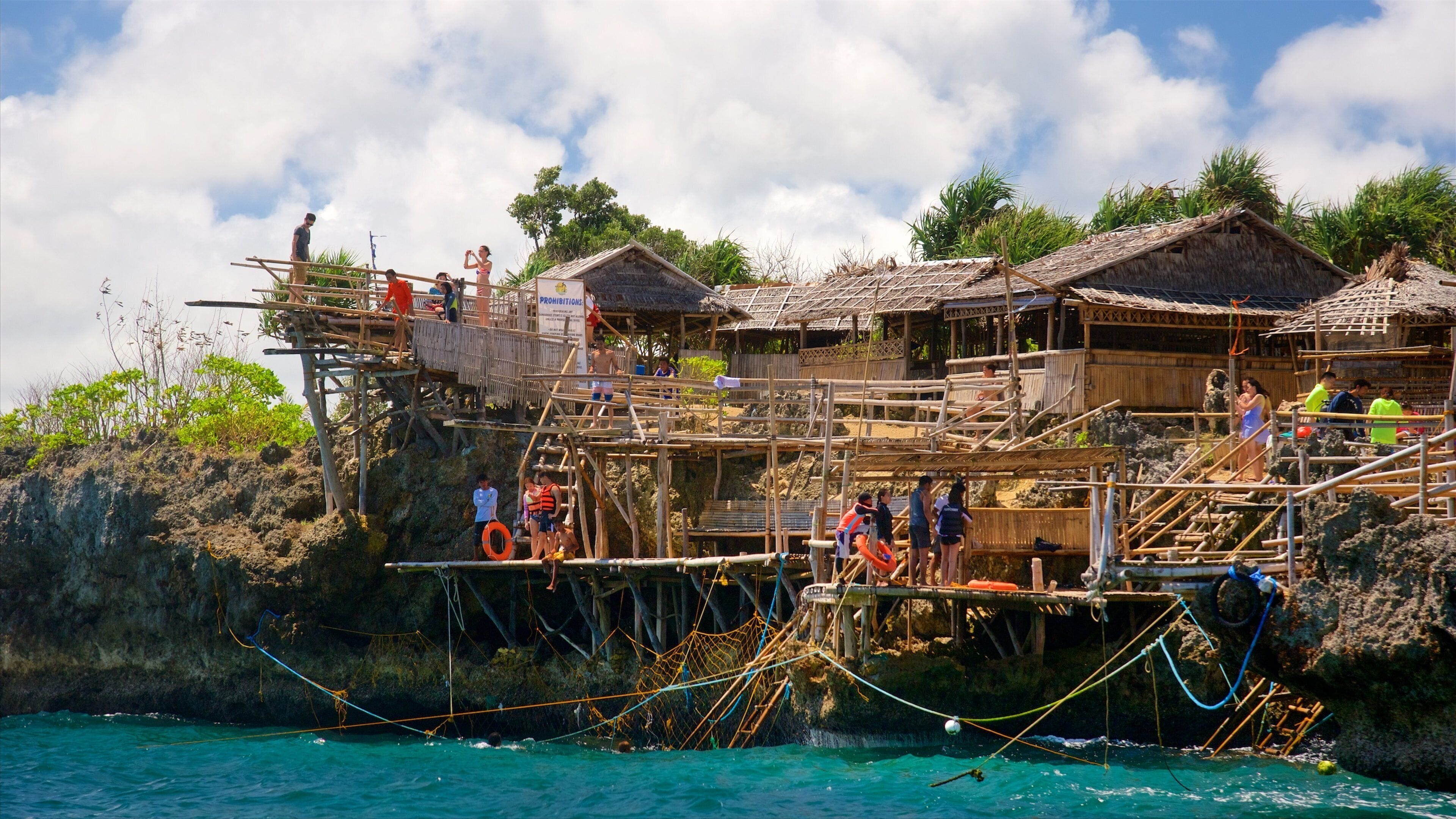 Boracay mettant en vedette côte rocheuse et scènes tropicales aussi bien que important groupe de personnes