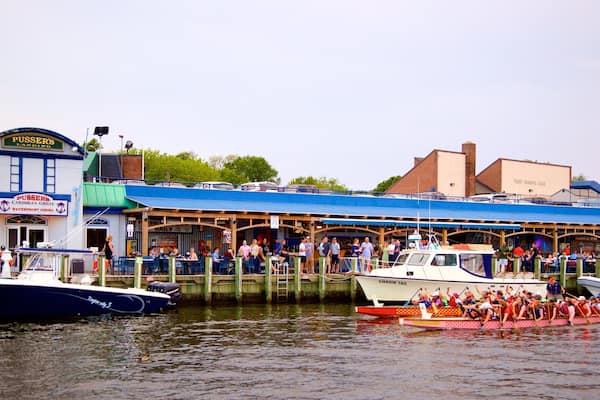 Un espacio de restauración frente al agua, con barcos amarrados cerca.