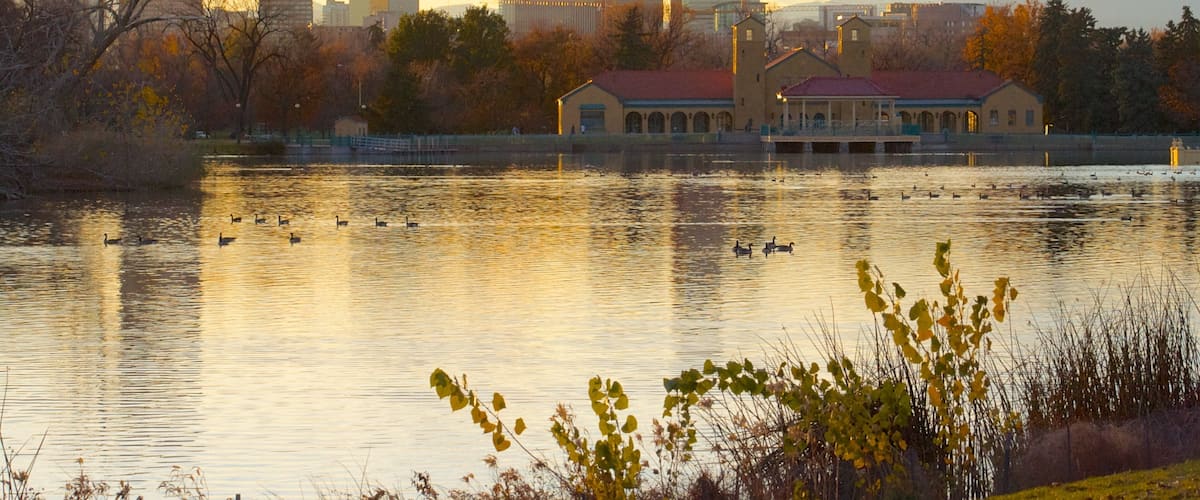 Sunset over City Park Lake with Denver skyline and autumn reflections