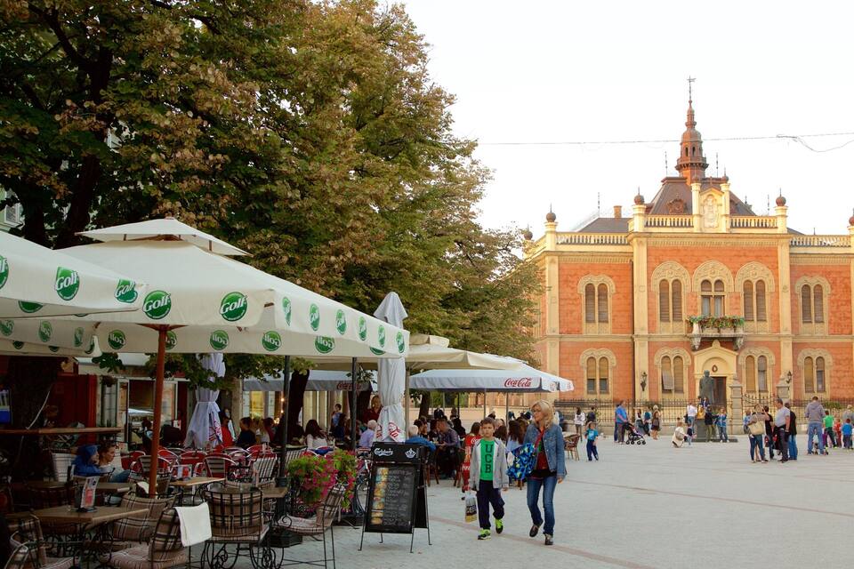 A bustling outdoor market with food stalls and people walking.