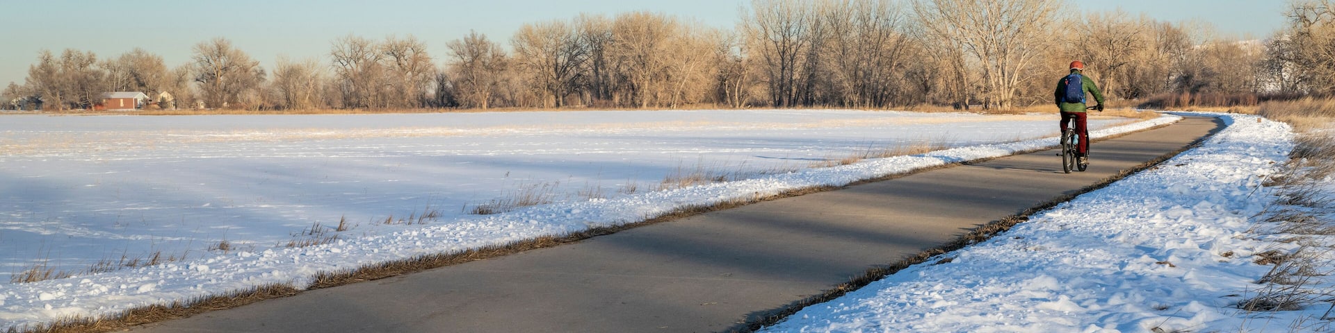 male cyclist commuting on a bike trail in winter scenery - Poudre River Trail panorama in northern Colorado