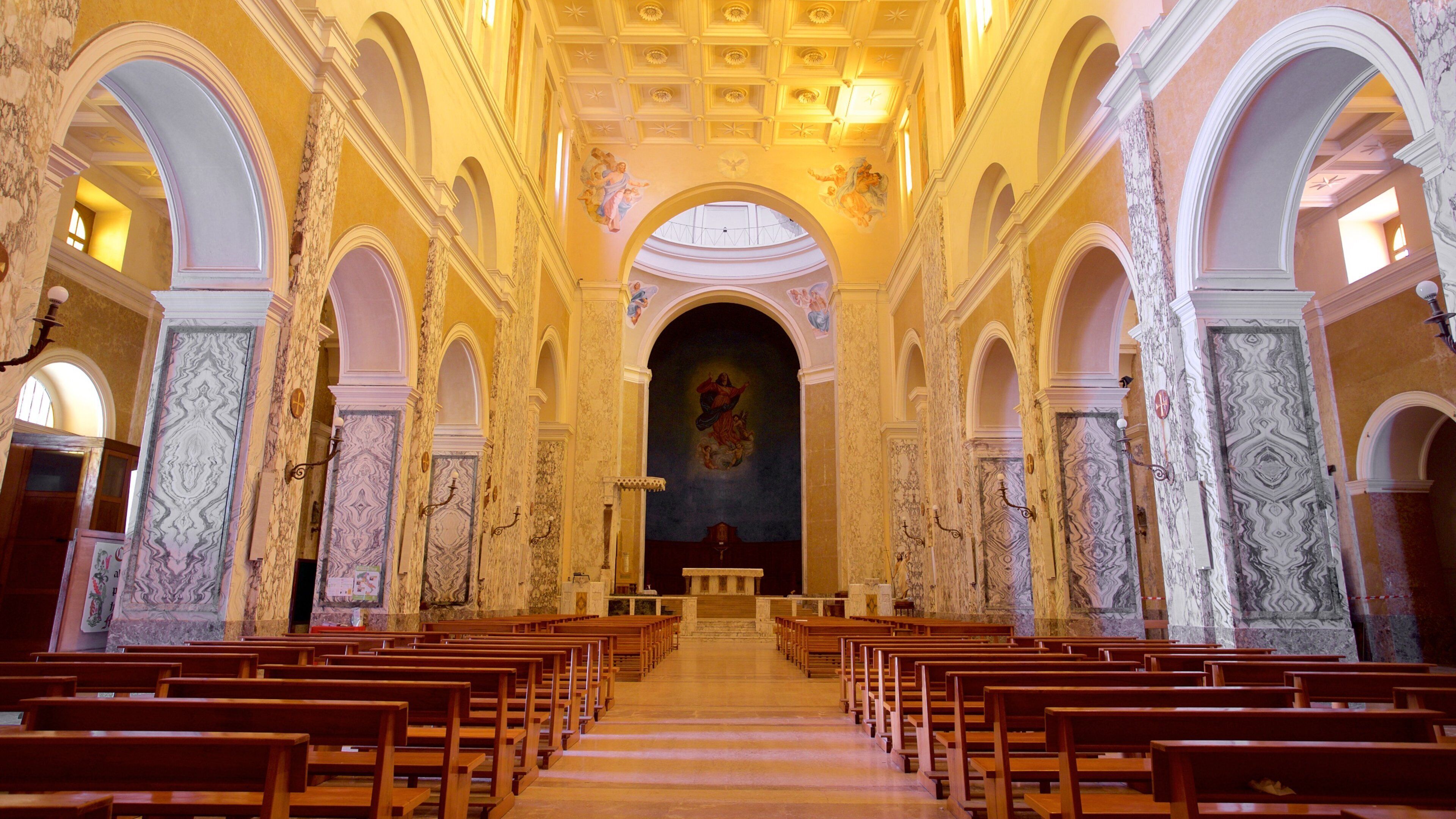 An interior of a church with wooden pews, marble columns, and a central altar.