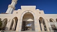 A mosque with a large archway, a minaret, and intricate tile work.