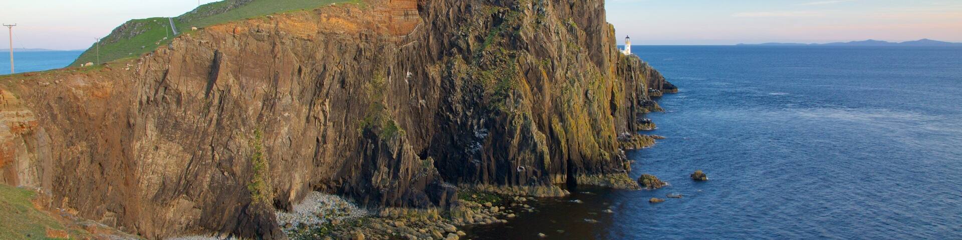 Isle of Skye which includes rocky coastline, a lighthouse and mountains