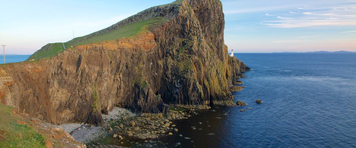 A rugged cliff by the sea with a lighthouse on top.