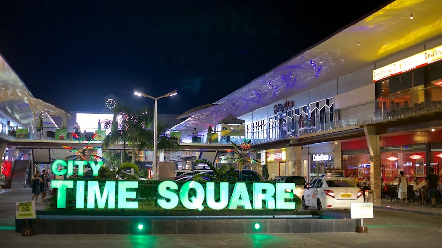 TIMES SQUARE, con insegne illuminate e un moderno centro commerciale sullo sfondo.