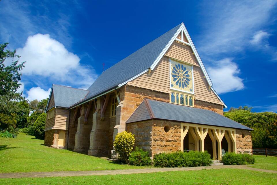A large stone church with a prominent clock tower and a triangular roof.
