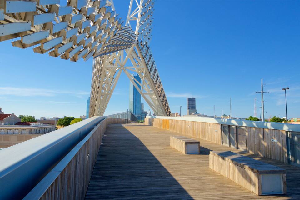 A pedestrian bridge with a wooden walkway and metal railings.