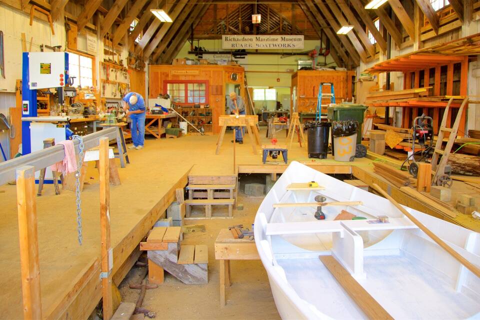 A woodworking shop with various tools and wooden boat parts.