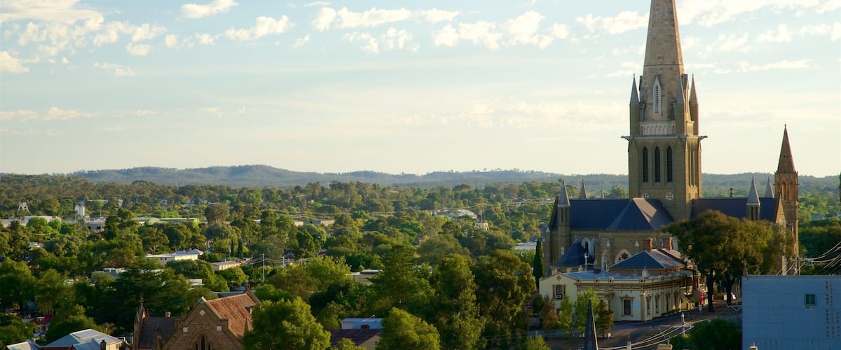 A church with a tall spire, surrounded by trees and buildings.