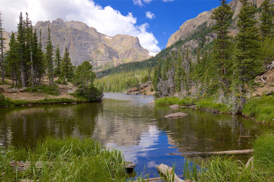 A mountain lake surrounded by dense forests and rocky cliffs.