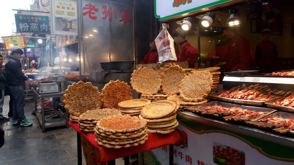 A street food stall with various types of flatbreads and meats displayed.