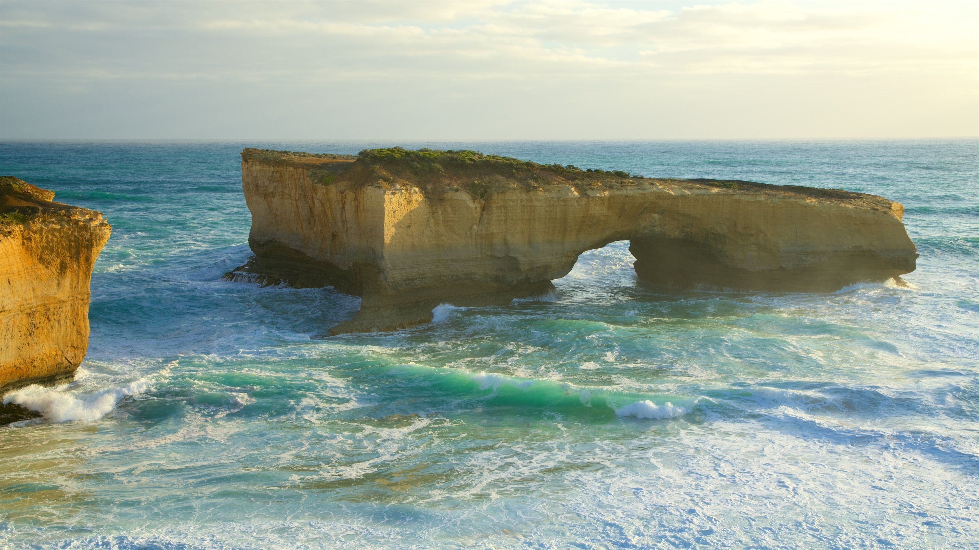 Port Campbell showing waves, a bay or harbour and rocky coastline