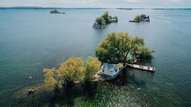 A lake with several small islands, one with a dock and a house, and another with a boat.