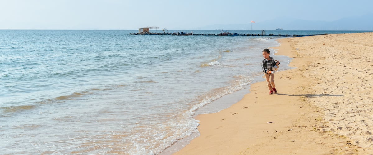 One Asian boy having fun at Xunliao Bay beach in Huizhou, Guangdong province, China, in January winter