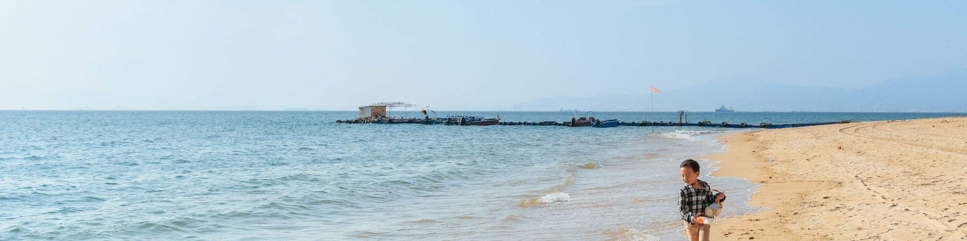 One Asian boy having fun at Xunliao Bay beach in Huizhou, Guangdong province, China, in January winter