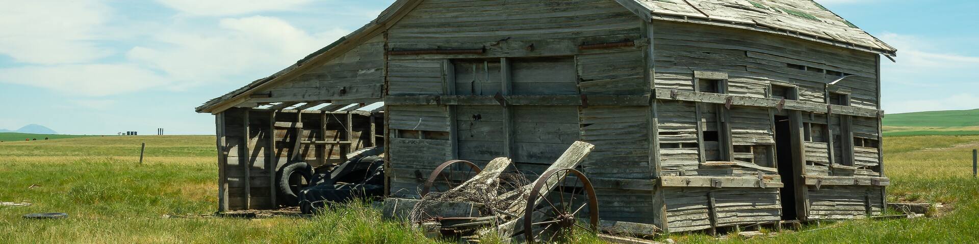 Abandoned house in the green field. Southern Alberta, Canada.