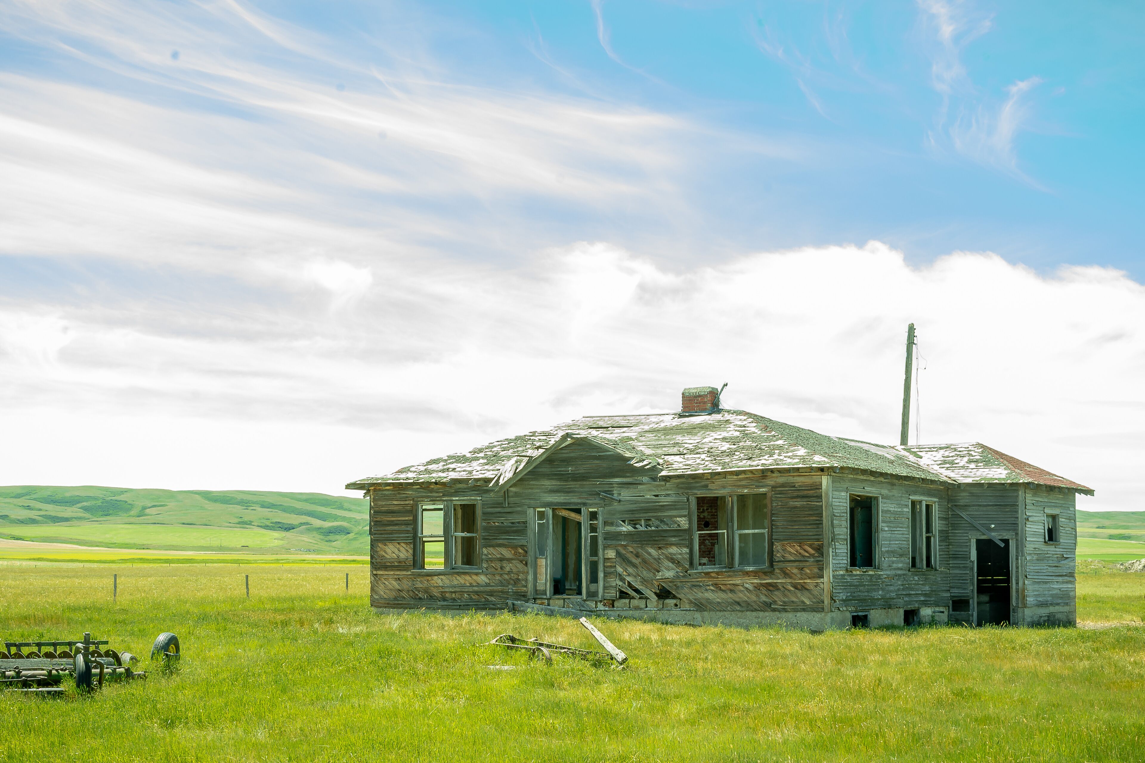 Abandoned house in the green field. Southern Alberta, Canada.
