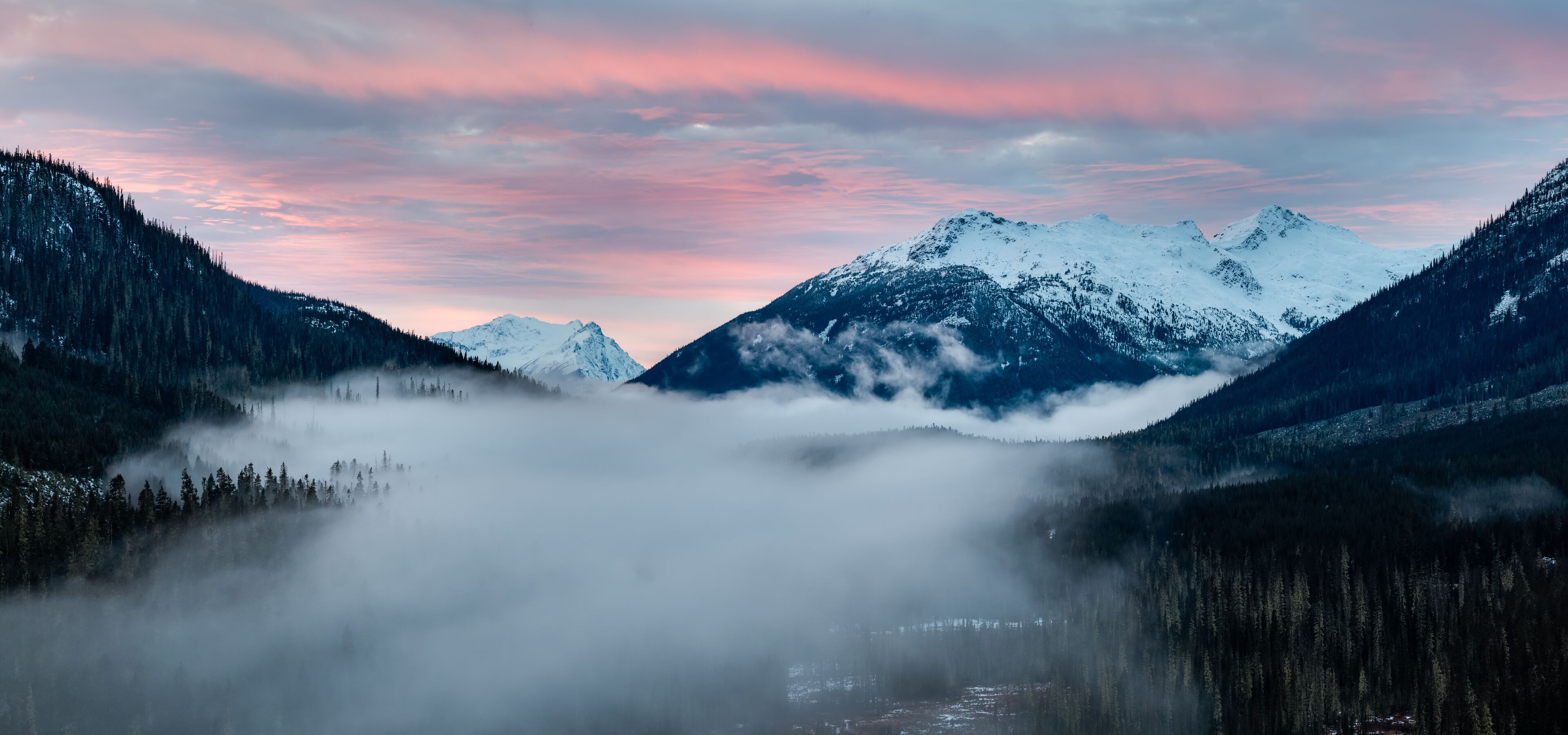 Sunrise Over Snowy Mountains in British Columbia With Misty Valley and Pink Sky