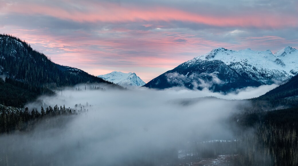 Sunrise Over Snowy Mountains in British Columbia With Misty Valley and Pink Sky