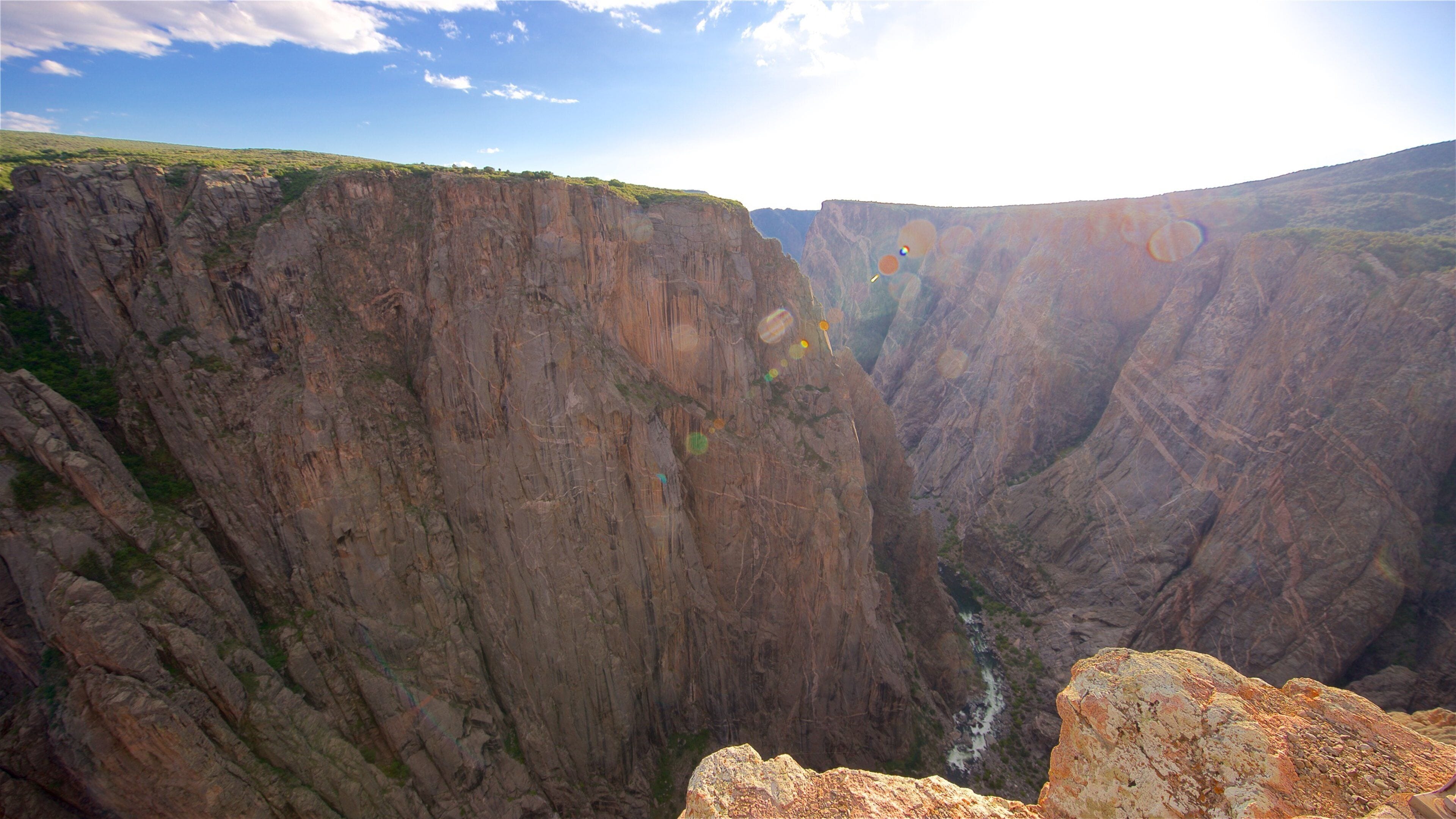 A canyon with steep cliffs and a river flowing through it.