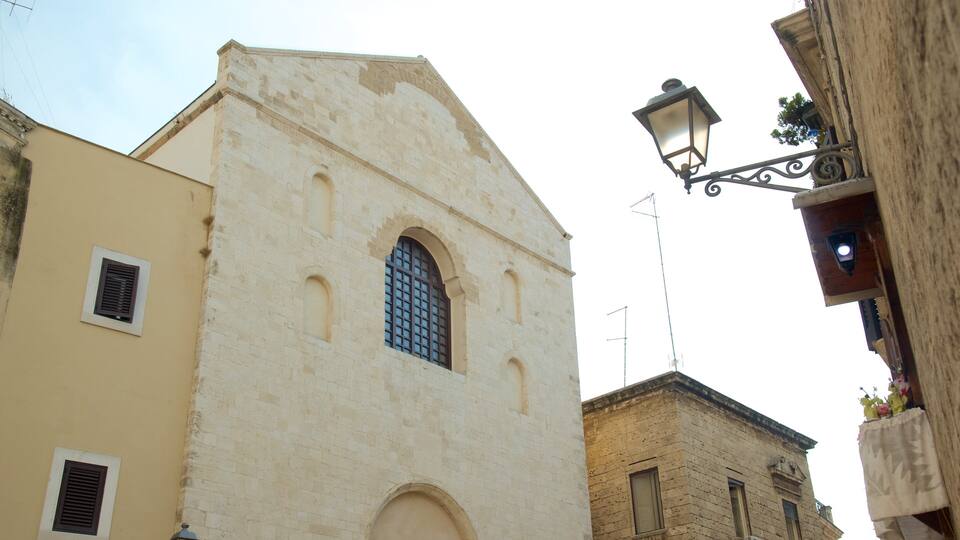A historic building with a prominent arched window and a small balcony.