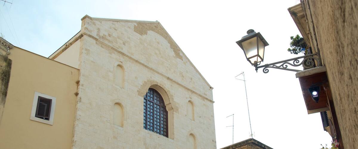 A historic building with a prominent arched window and a small balcony.