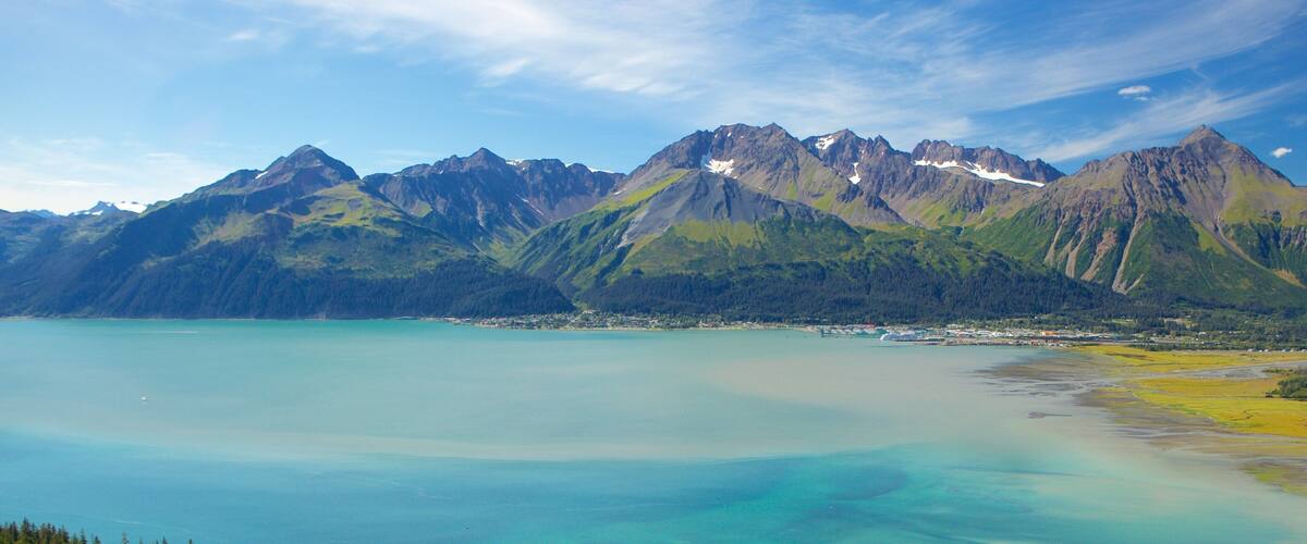 A mountain range with a clear lake and dense forest.