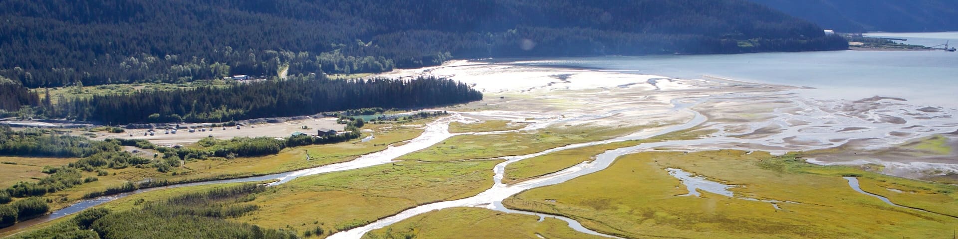 A river winding through a valley with mountains in the background.