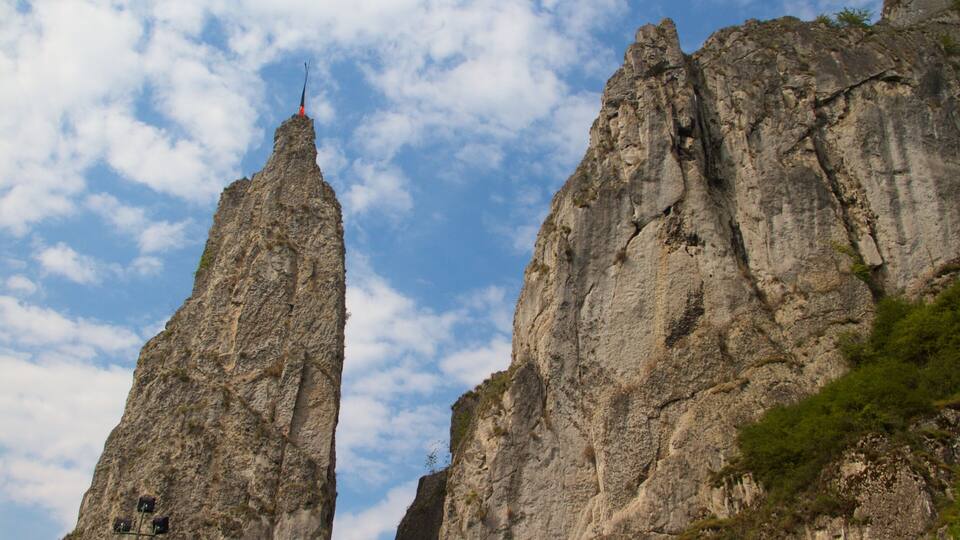 Two tall, rugged rock formations with a clear sky in the background.